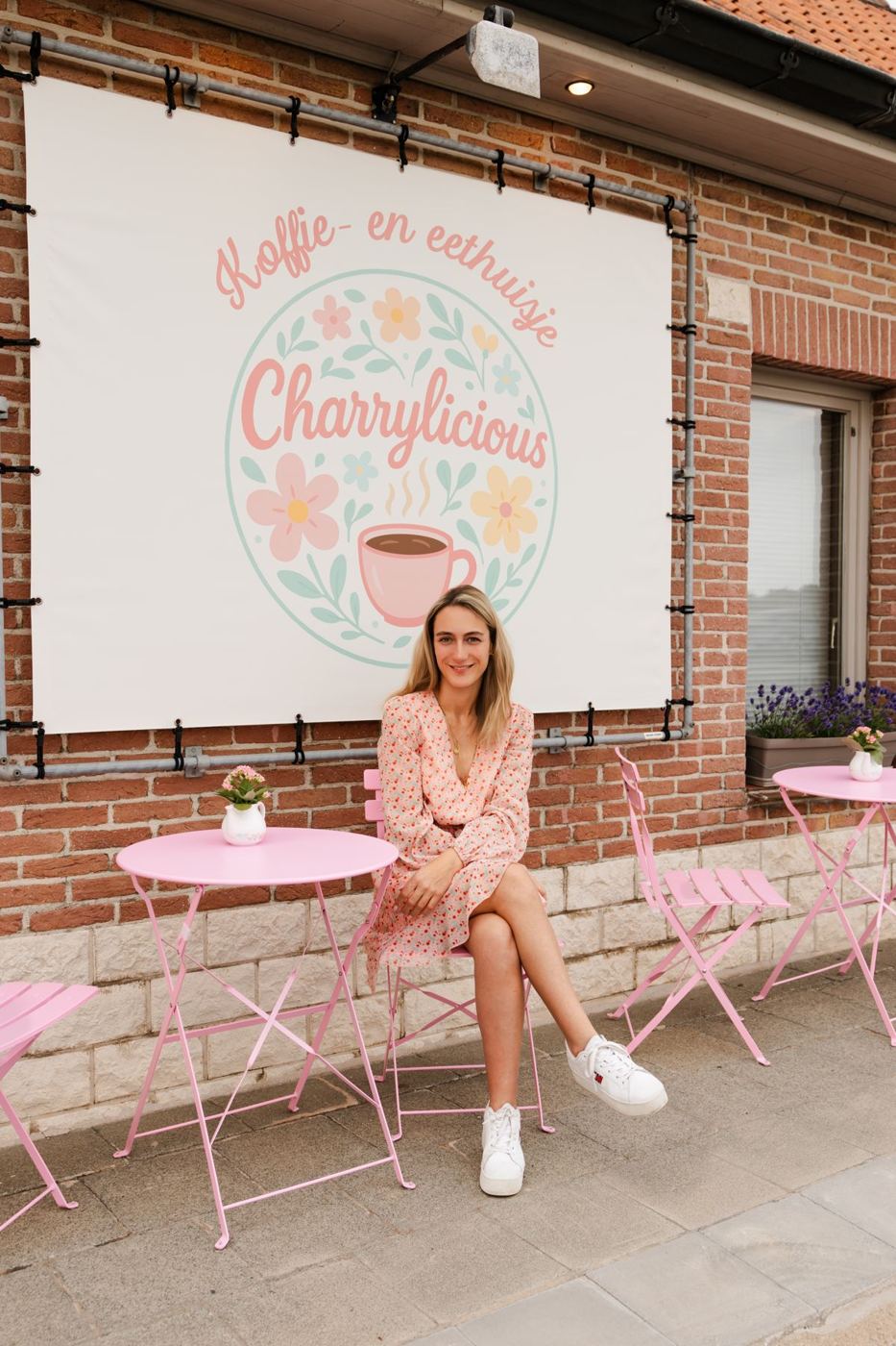 Charry op het roze terras voor haar zaak
